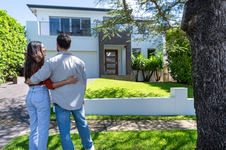 couple looking at their house with their arms around each other